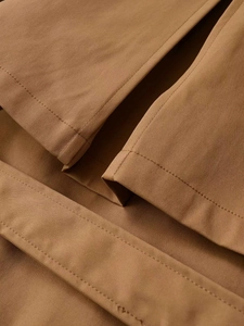 Close-up of high-density khaki cotton twill fabric with precise flat seam stitching
