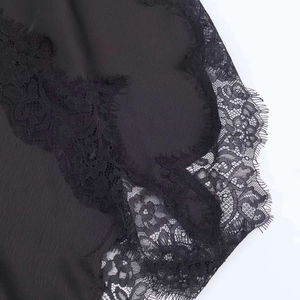 Vue détaillée du tissu satiné noir avec bordure en dentelle cil et coutures délicates