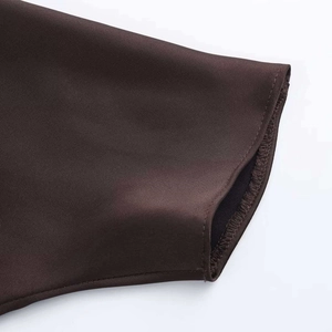 Detail of dark brown satin dress showing high-quality hem stitching and silky fabric texture