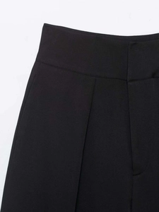 Details der hoch taillierten Faltenhose mit schwarzer Stoffstruktur und feiner Naht