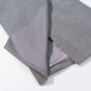 Close-up of grey wool coat hem showing high-quality stitching and smooth inner lining