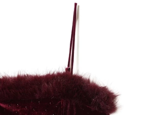 Detailed close-up of burgundy velvet dress with fluffy faux fur trim and shimmering beads