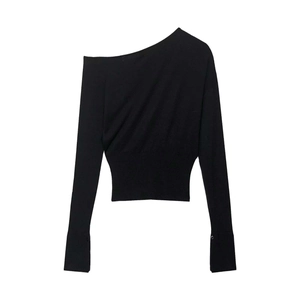 Detail of black one-shoulder knit top featuring elegant sleeve buttons and waist ruching