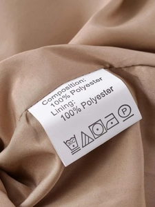 Close-up of the wash care label showing 100% polyester fabric on the khaki trench coat