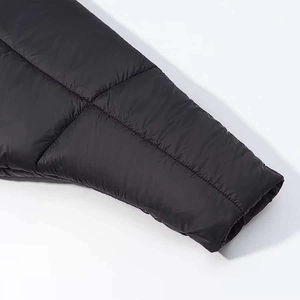 Detailed close-up of quilted black puffer jacket sleeve showing premium satin fabric texture