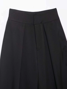 Detail der schwarzen High-Waist-Hose mit Falten-Design und Knopfverschluss am Bund