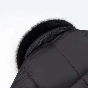 Detailed view of luxury black faux fur collar and quilted waterproof fabric on parka coat