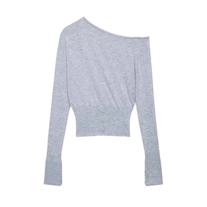 Detail of off-shoulder grey knit top with ribbed cuffs and decorative waist buttons