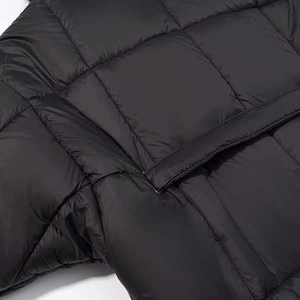 Close-up of black puffer jacket with large square quilting and premium nylon fabric