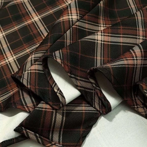 Gros plan détaillé sur la texture du tissu plissé à carreaux marron au style vintage