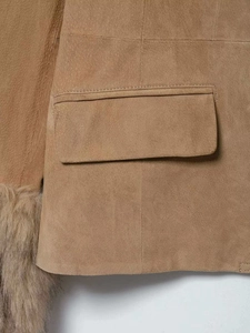 Détail de la veste en daim fauve avec poches à rabat et bordures en fausse fourrure
