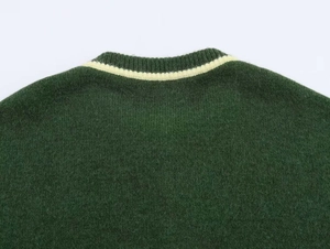 Close-up of the dark green knit sweater featuring a contrasting cream striped collar detail