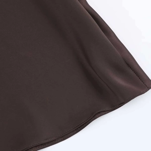 Detail of dark brown satin dress hemline showing smooth texture and fine stitching