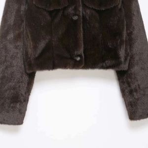 Short faux fur jacket in dark brown with button closure and flap pockets on white background
