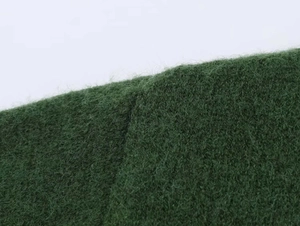 Close-up of premium dark green knit fabric with soft mohair texture for autumn sweater