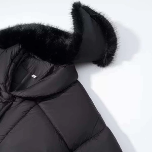 Detail of the hooded winter coat with high-quality faux fur trim and quilted fabric texture