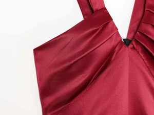 Detailed view of the luxurious burgundy satin fabric and delicate pleats on the V-neck dress