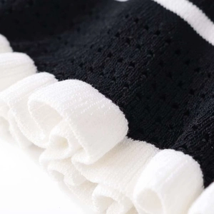 Contrast color hollow knit sweater featuring ruffled white edges and layered textures