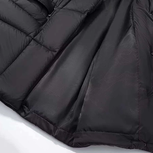Detail of waterproof matte black quilted fabric and seamless inner lining on winter coat