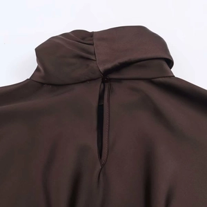 Detail view of coffee satin dress featuring twisted high neck and keyhole back with button