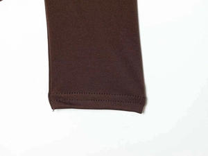 Detailopname van de donkerbruine gebreide bodysuit mouw met hoogwaardige stiksels