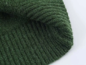 Detailed macro view of dark green ribbed knit fabric with soft mohair texture