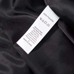 Detailed view of the 100% polyester fabric care label on a black winter jacket
