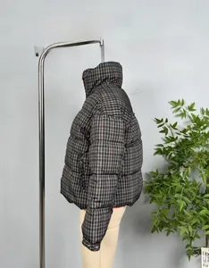 Detail shot of the red and black plaid quilted puffer jacket featuring a stand-up collar