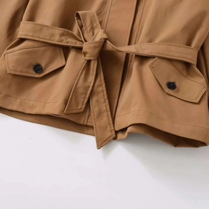 Women's khaki trench coat featuring a belted waist and decorative black buttons