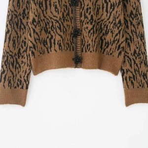 Short knit cardigan with brown animal jacquard and black 3D flower buttons