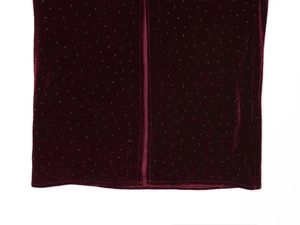 Close-up of burgundy velvet dress fabric featuring sparkling rhinestones and clean hemline