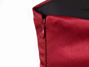 Detail shot of invisible zipper closure on the burgundy satin V-neck dress with black lining
