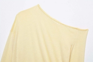 Detailed macro view of the pale yellow knitwear neckline and fine knitting texture