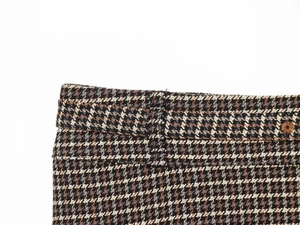 Détail de la taille d'une jupe en laine à motif pied-de-poule avec passants et bouton