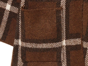 Detailed close-up of dark brown plaid knit fabric texture and hidden pocket craftsmanship
