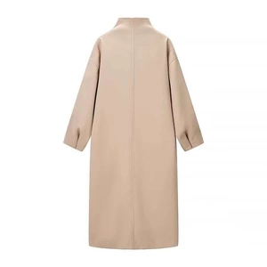 Detail of camel long coat showing the minimalist stand-up collar and vertical back stitching