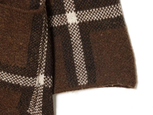 Close-up of thick knitted fabric texture with classic brown and white plaid check pattern