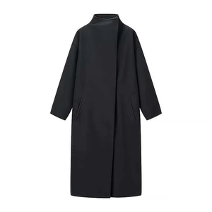 Detail of black wool coat featuring standing collar, hidden placket, and side pockets