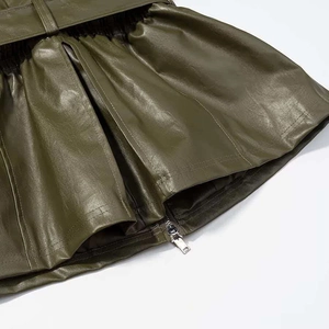Detail of olive green PU leather skirt featuring pleated waist belt and metal zipper