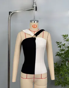 Detail of slim fit ribbed knit halter top with gold buckle and black-white contrast