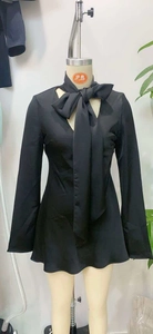 Detail of elegant black long sleeve satin dress with large bow-knot and V-neckline