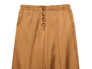 Detailed macro view of satin fabric texture and covered buttons on bronze high waist pants