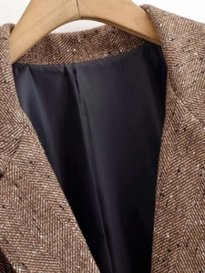 Detail of herringbone wool blazer lapel with brown tweed fabric and smooth black lining