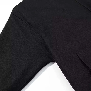 Close-up of precise stitching on black wool coat shoulder and armhole seam details