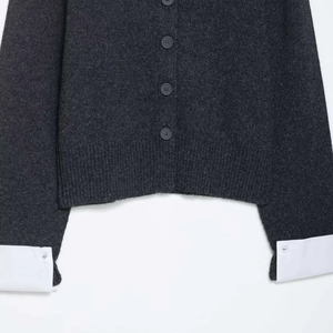 Dark grey knit cardigan with contrast white shirt cuffs and button details