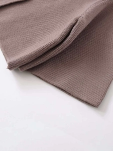 Nahaufnahme der feinen Stricktextur einer kaffeebraunen Strickjacke mit weichem Fall