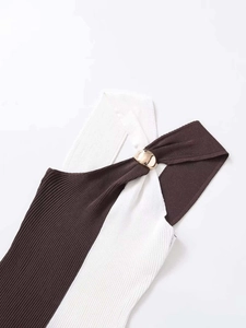 Close-up of contrast knit tank top with brown and white panels and a gold metal ring