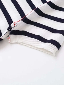 Macro detail of black and white striped knitwear with decorative red seam stitch line