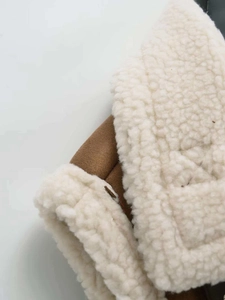 Detailed macro view of the brown faux suede and cream faux shearling lining texture