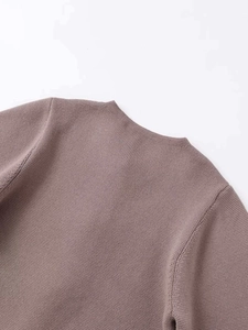 Detail der Waffelstrick-Textur und des Rundhalsausschnitts an einer Puderrosa-Jacke